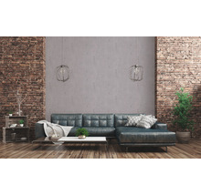 Wohnzimmer mit Ecksofa, Couchtisch, Regalen und Ziegelwand