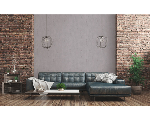 Wohnzimmer mit Ecksofa, Couchtisch, Regalen und Ziegelwand