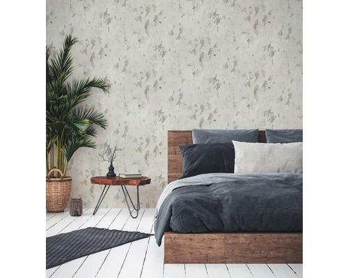 Schlafzimmer mit gemusterter Tapete, Holzbett und Zimmerpflanze.