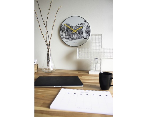 Dekorativer Schreibtisch mit Wanduhr, Laptop, Tasse und Kalender.