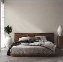 Schlafzimmer mit Bett, Holzkopfteil und hellfarbiger Tapete
