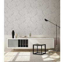 Wohnraum mit Marmortapete, Sideboard, Hocker und Stehlampe