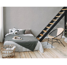Helles Schlafzimmer mit Bett, Leiter, Korb und Stuhl auf Holzboden