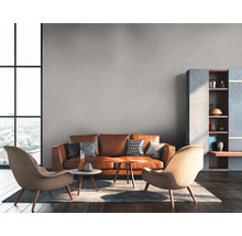 Wohnzimmer mit braunem Ledersofa, zwei Sesseln, Couchtischen und Regal
