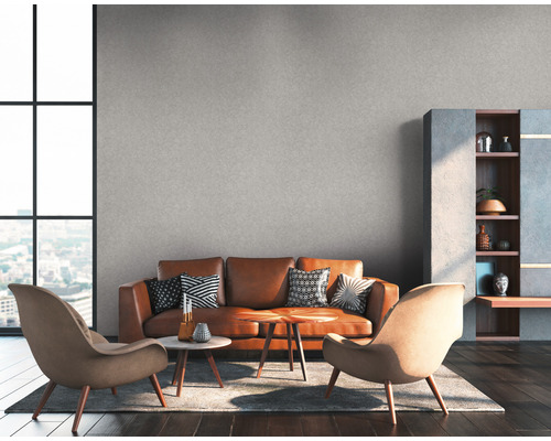 Wohnzimmer mit braunem Ledersofa, zwei Sesseln, Couchtischen und Regal