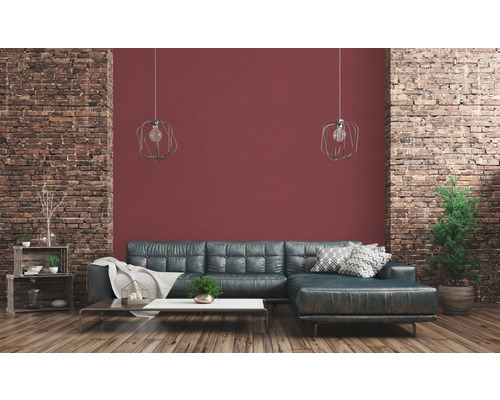 Wohnzimmer mit Ledersofa, Couchtisch, Dekoration und Backsteinmauer