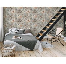 Ein Schlafzimmer mit einem Bett, einem Stuhl und einer Treppe vor einer Wandtapete mit Fleckmuster.