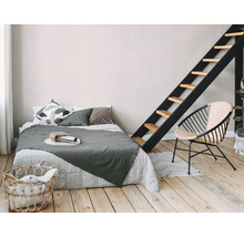 Schlafzimmer mit Bett, Leiter, Korbsessel und Wäschekorb.