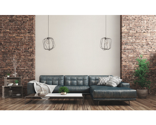 Wohnzimmer mit Sofa, Couchtisch, Regalen und Dekoration vor einer Ziegelwand