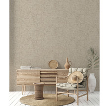 Beige textile Oberfläche als Wandgestaltung in einem Wohnraum mit Kommode und Sessel.