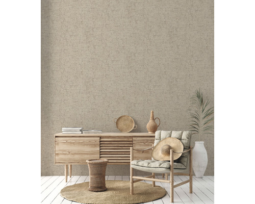 Beige textile Oberfläche als Wandgestaltung in einem Wohnraum mit Kommode und Sessel.