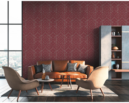 Wohnzimmer mit braunem Ledersofa, Sessel und einer Wand mit geometrischer Tapete