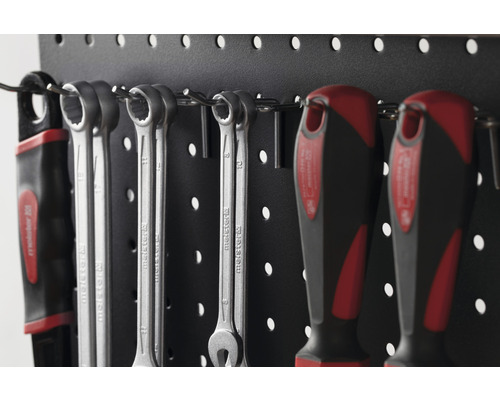 Werkzeuge wie Schraubenschlüssel und Schraubendreher an einer Lochwand