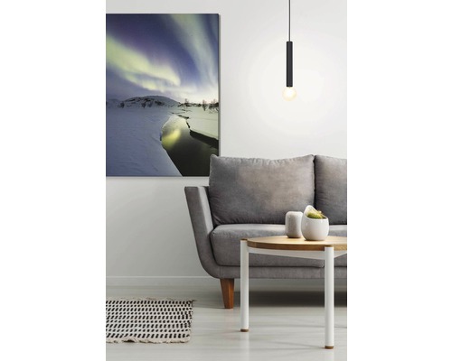 Wohnzimmer mit grauer Couch, Tisch, Hängelampe und einem Wandbild mit einer Winterlandschaft unter dem Nordlicht.