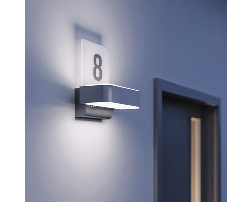 Beleuchtetes Hausnummernschild mit der Nummer 8 neben einer Tür