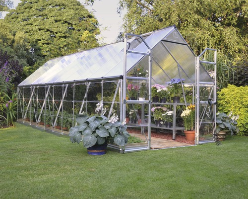 Gewächshaus Palram – Canopia Balance 8x20 244 x 607 cm silber Gewächshaus mit Pflanzen im Garten.