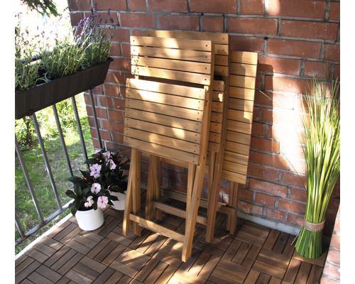 Szene eines Balkons mit Klapptischen aus Holz, Topfpflanzen und Ziegelwand