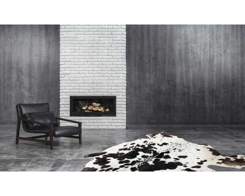 Wohnzimmer mit Sessel, Kamin und Teppich im Kuhfell-Design