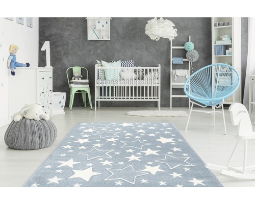Kinderzimmer mit blauem Teppich und Sternenmuster, Gitterbett und Spielzeug