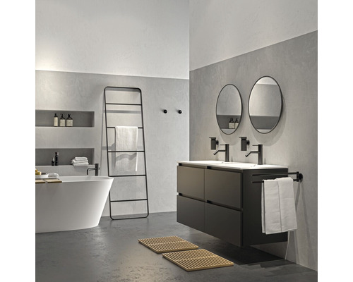 Badezimmer mit Badewanne, Waschtisch, Spiegeln und Handtuchleiter in modernem Design.