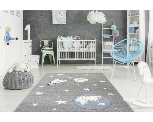 Kinderzimmer mit Teppich, Babybett, Sessel und Spielzeug