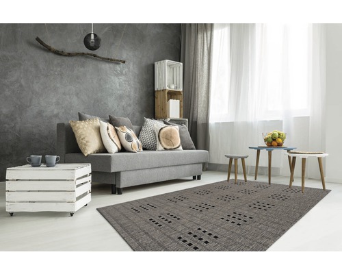 Modernes Wohnzimmer mit grauem Sofa, Dekokissen, Holzkistenmöbeln und gemustertem Teppich