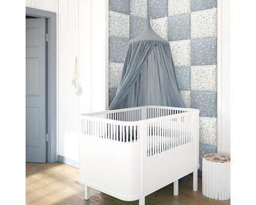 Wandkissen Set Print Weltall Samt-Optik 30 x 30 cm 4 Stk Kinderzimmer mit weißem Gitterbett und blauem Betthimmel vor einer gemusterten Wand