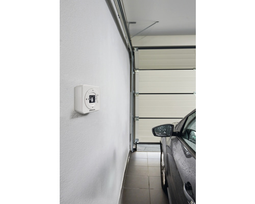 Garageninnenszene mit Garagentoröffner an der Wand und einem Auto