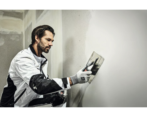 Handwerker glättet eine Wand mit einer Glättkelle.