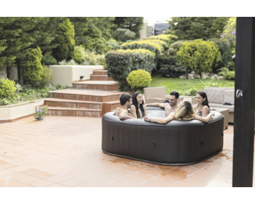 Aufblasbarer Whirlpool im Garten mit entspannten Personen.