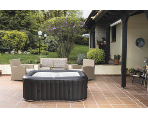 Aufblasbarer Whirlpool auf einer Terrasse mit Gartenmöbeln und Pflanzen