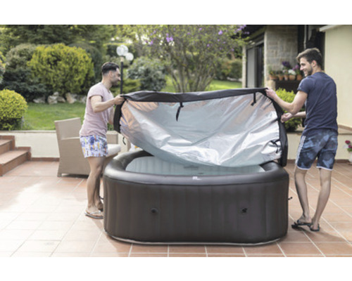 Zwei Männer entfernen die Abdeckung von einem aufblasbaren Whirlpool im Garten.