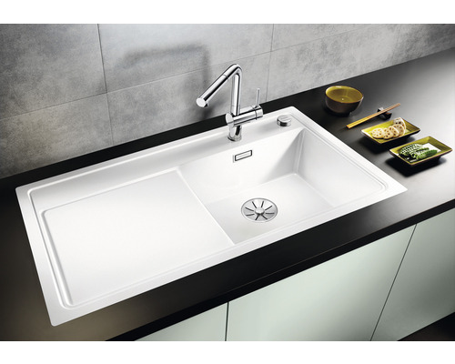 Spültisch mit Abtropffläche, Armatur und Zubehör auf einer Küchentheke