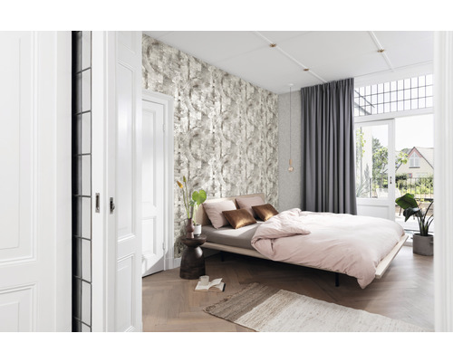 Helles Schlafzimmer mit Bett, Mustertapete, Vorhängen und Holzboden