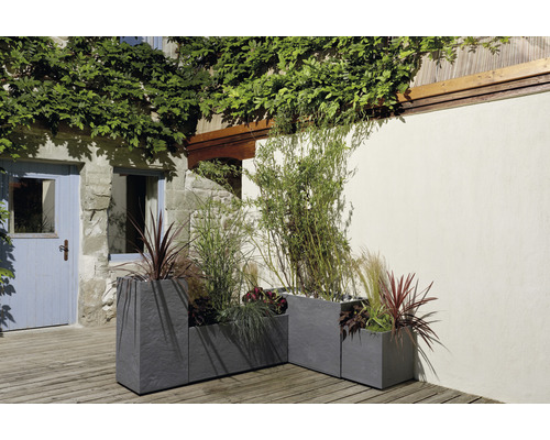 Drei graue Pflanzkästen aus Steinzeug mit Bepflanzung im Außenbereich.