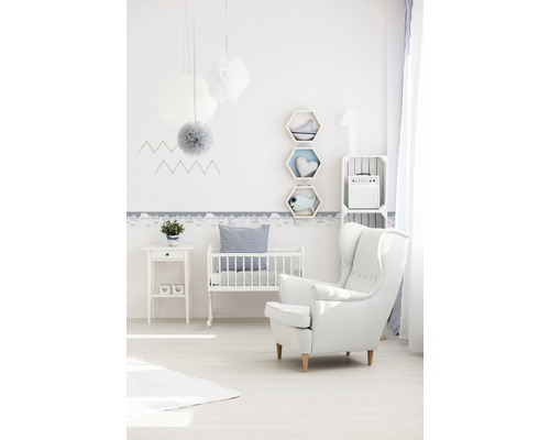 Kinderzimmer mit Babybett, Sessel und Wanddekorationen