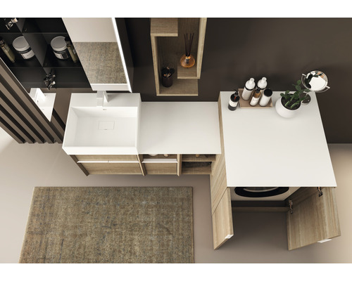 Ansicht von oben eines Badezimmers mit Waschtisch, Spiegel, Regalen, Waschmaschine und Teppich