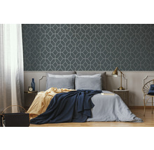 Schlafzimmer mit geometrischer Tapete und Bett