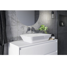 Modernes Badezimmer mit Aufsatzwaschbecken, rundem Spiegel und Betonwand