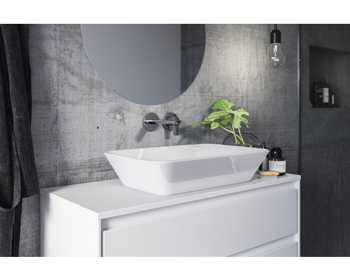 Modernes Badezimmer mit Aufsatzwaschbecken, rundem Spiegel und Betonwand