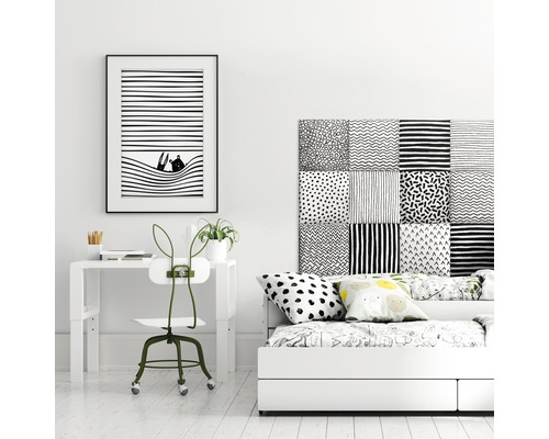 Einrichtung eines Zimmers mit Schreibtisch, Stuhl und Bett in Schwarz und Weiß.