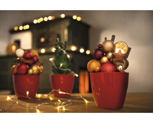 Dekorative Weihnachtsszene mit roten Töpfen, Christbaumkugeln, Sternen und Lichtern