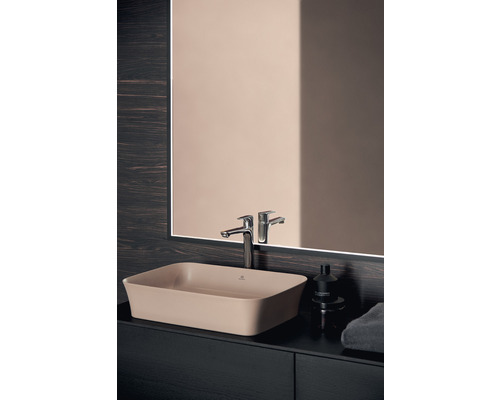 Waschbecken aus Keramik mit Armatur und Spiegel im Badezimmer