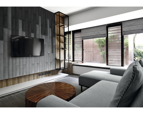 Wohnzimmer mit Sofa, Fernseher und Regal.