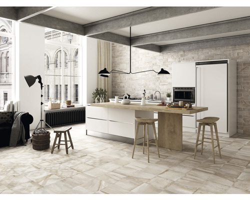 Heller Wohnraum mit Fliesenboden, Kücheninsel und hohen Decken.