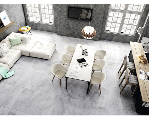 Helles Wohnzimmer mit Fliesenboden, Sofa, Esstisch und Stühlen