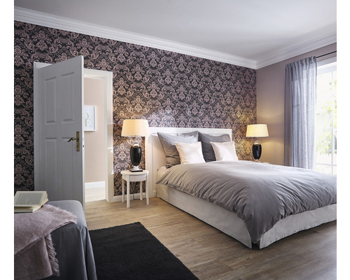 Schlafzimmer mit Bett, Nachttischen, Lampen und gemusterter Tapete