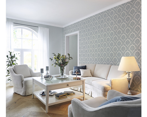Wohnzimmer mit Sofa, Sesseln, Couchtisch und gemusterter Tapete für ein stilvolles Ambiente