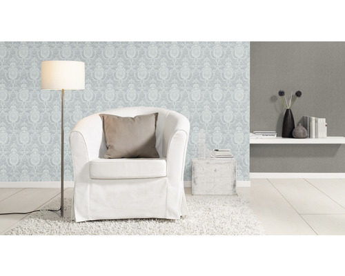 Wohnzimmer mit Sessel, Stehlampe und gemusterter Tapete