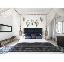 Schlafzimmer mit Doppelbett, Nachttischlampen, Traumfängern und blauen Textilien